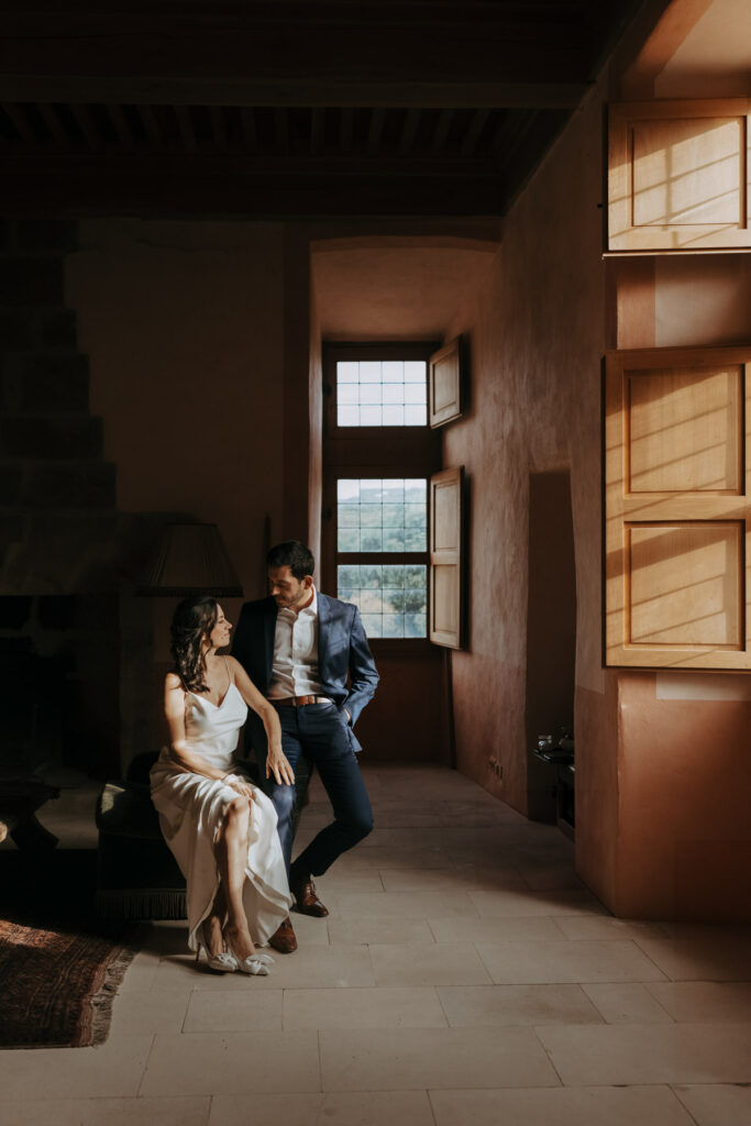 couple de mariés élégants assis dans la lumière d'un château en Occitanie - Photographe mariage