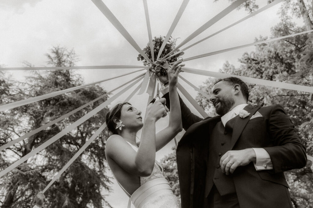 mariés lors du jeu du ruban pendant le vin d'honneur- photo en noir et blanc - photographe mariage occitanie
