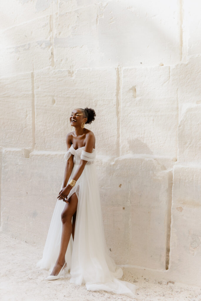 photographe mariage dans le Sud de la France - femme mariée dans sa robe posant devant un mur en pierre